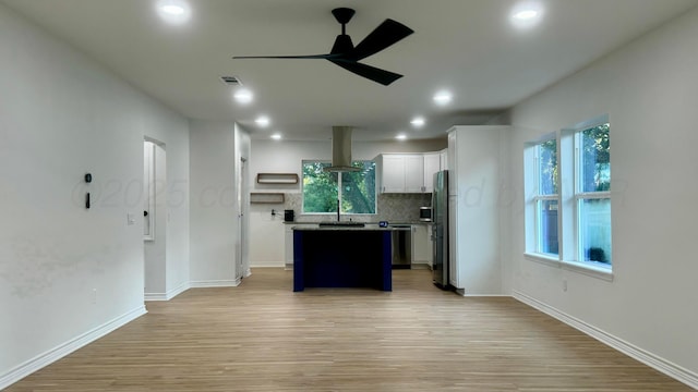 kitchen with island range hood, a kitchen island, ceiling fan, decorative backsplash, and white cabinets