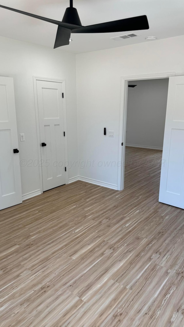 empty room featuring ceiling fan and light wood-type flooring