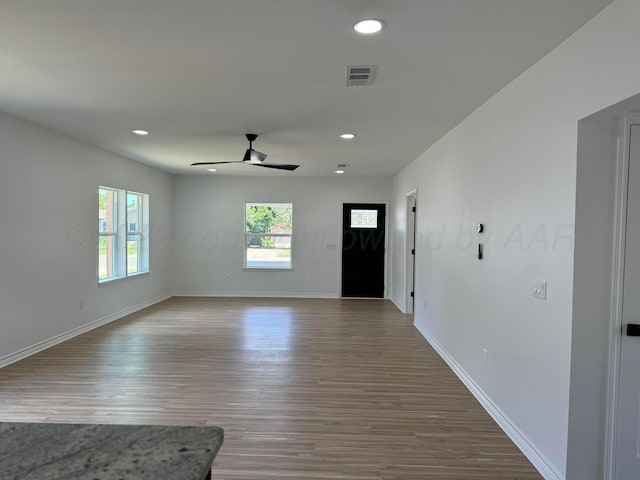 unfurnished living room featuring ceiling fan and hardwood / wood-style floors