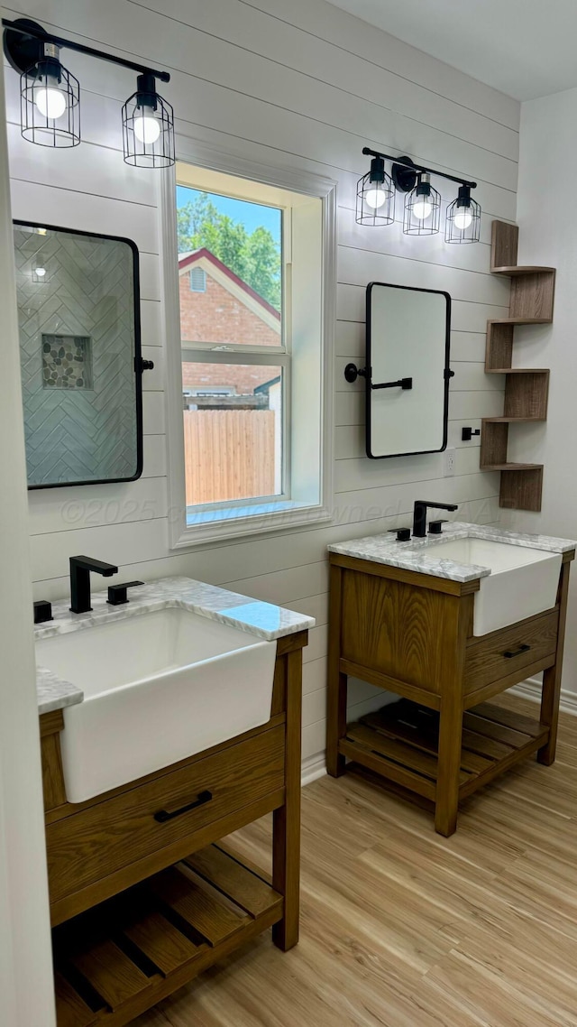 bathroom featuring hardwood / wood-style flooring, vanity, and wooden walls