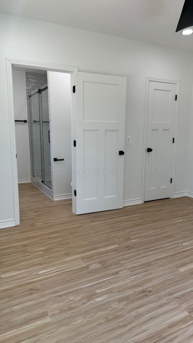 spare room with ceiling fan and light wood-type flooring