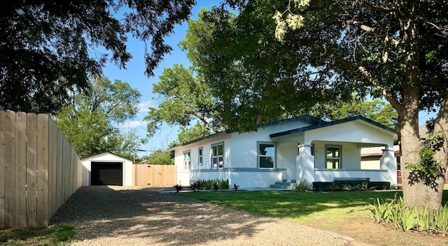 view of front of property with a garage, an outdoor structure, and a front yard