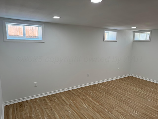 basement with light hardwood / wood-style flooring