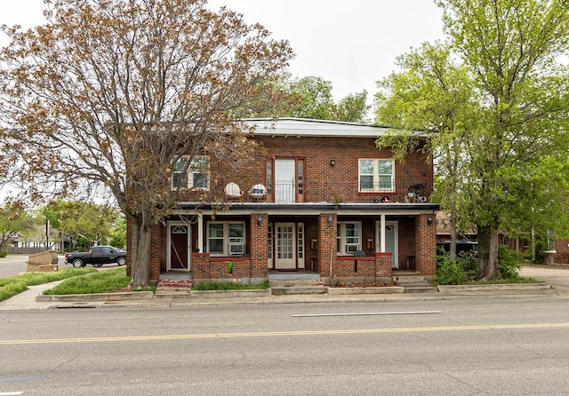 view of front of home featuring a porch and brick siding