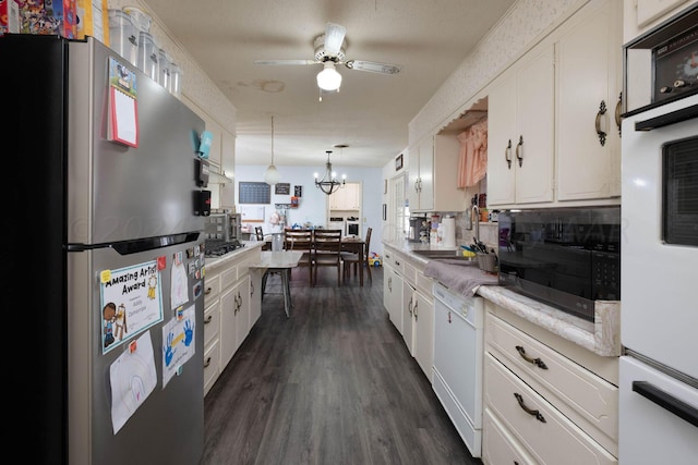 kitchen featuring white appliances, white cabinets, dark wood-type flooring, sink, and hanging light fixtures