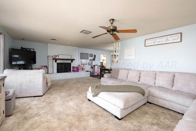 carpeted living room with ceiling fan, a fireplace, and a textured ceiling