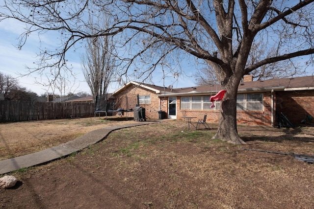 view of front of home with a front lawn and a trampoline