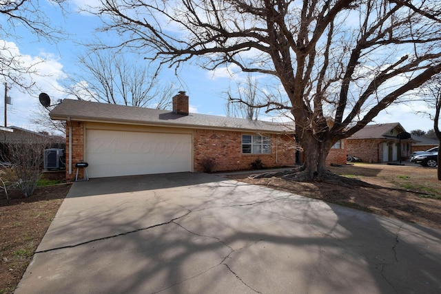 ranch-style home with cooling unit and a garage