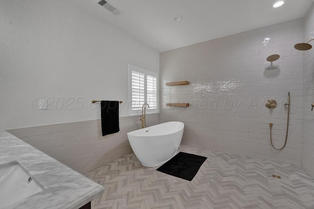 6007 Riley Elizabeth Dr, Amarillo, TX 79119 - bathroom with visible vents, vanity, tile walls, a walk in shower, and a freestanding bath