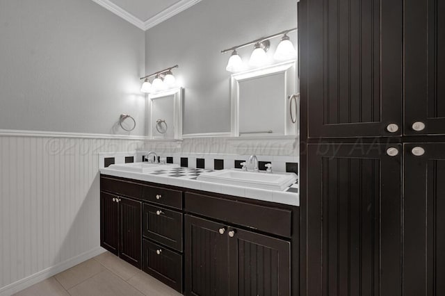6007 Riley Elizabeth Dr, Amarillo, TX 79119 - bathroom featuring double vanity, crown molding, a sink, tile patterned floors, and a wainscoted wall