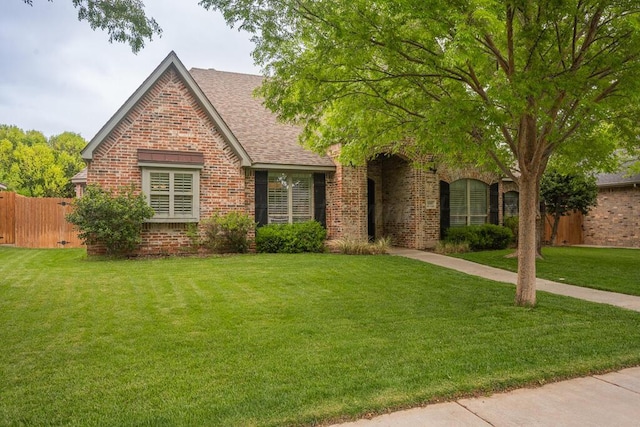 6007 Riley Elizabeth Dr, Amarillo, TX 79119 - view of front facade featuring fence, a shingled roof, a front yard, and brick siding