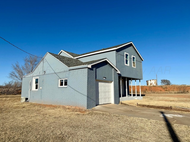 view of property exterior with a garage, brick siding, and driveway