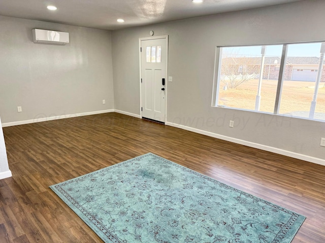 entryway featuring dark wood-type flooring, baseboards, and a wall mounted AC