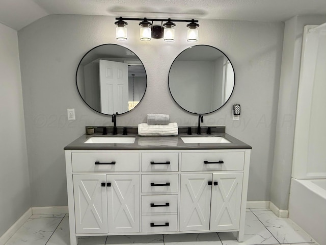 full bathroom featuring double vanity, marble finish floor, and a sink