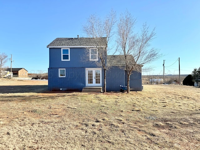 back of property with entry steps, brick siding, a lawn, and french doors