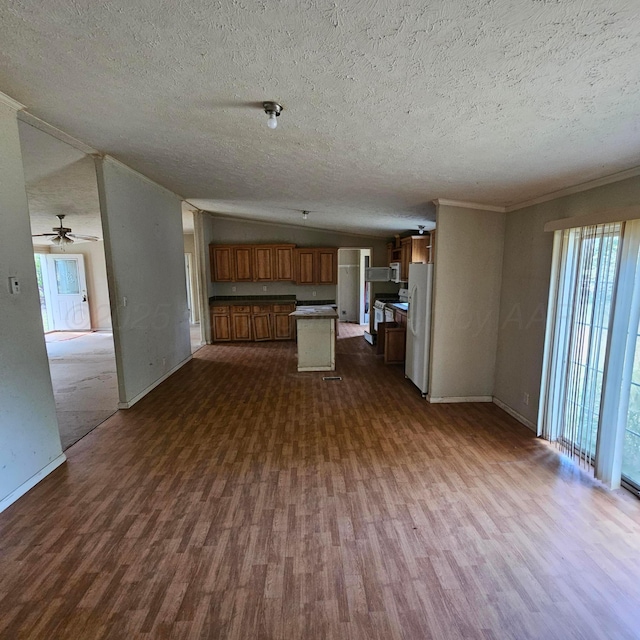 unfurnished living room featuring a textured ceiling, dark hardwood / wood-style flooring, lofted ceiling, and ornamental molding