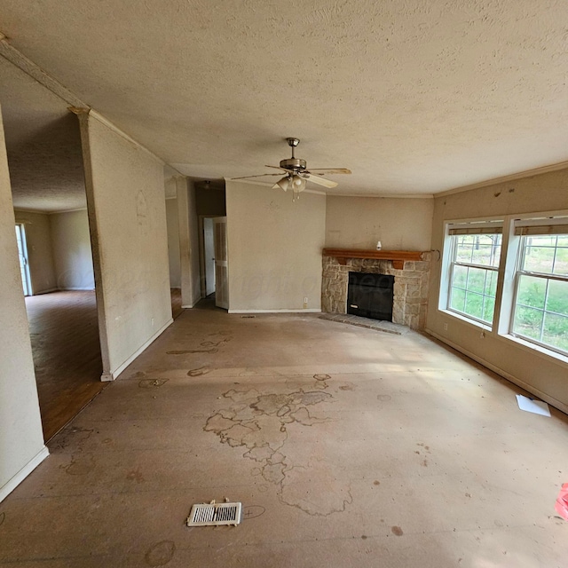 unfurnished living room with a stone fireplace, ceiling fan, and a textured ceiling