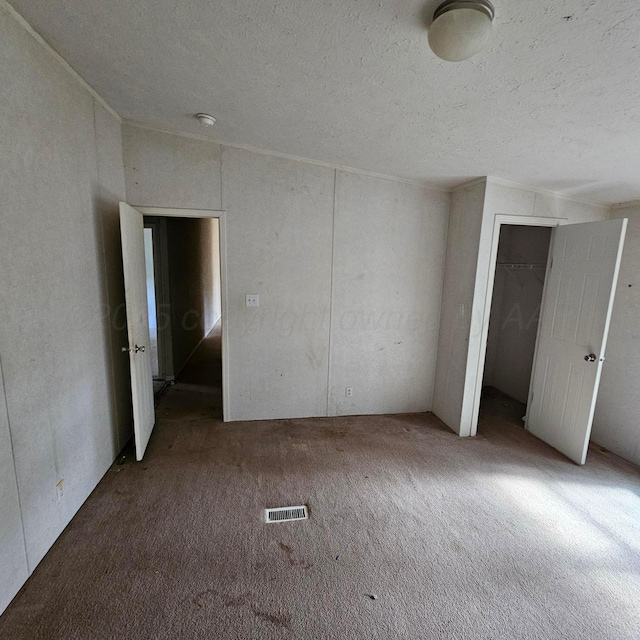 carpeted spare room with a textured ceiling