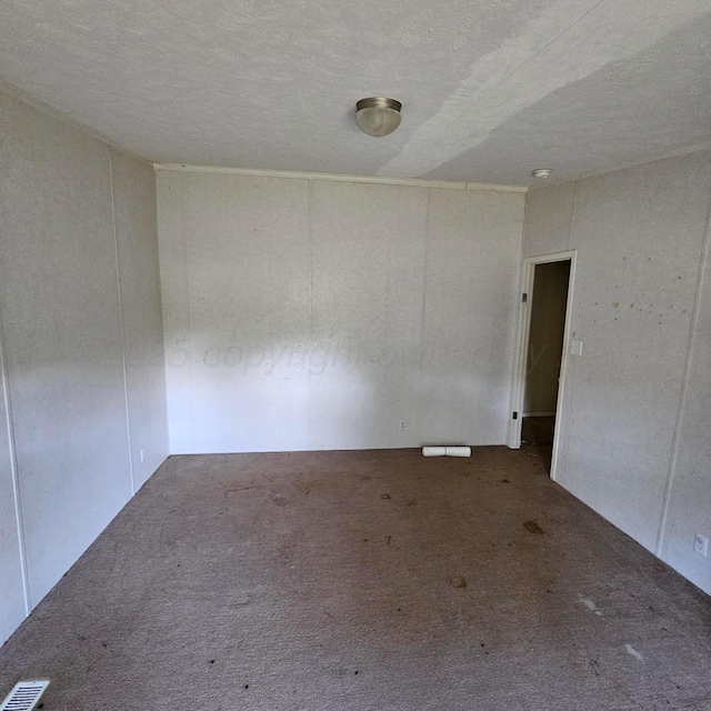 carpeted empty room with a textured ceiling