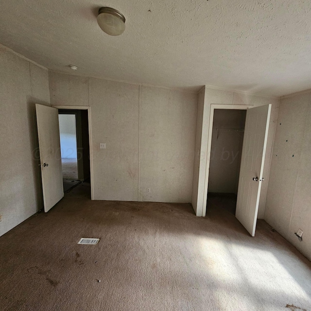 unfurnished bedroom with carpet and a textured ceiling