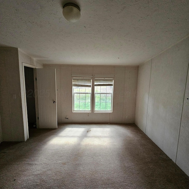 carpeted spare room with a textured ceiling