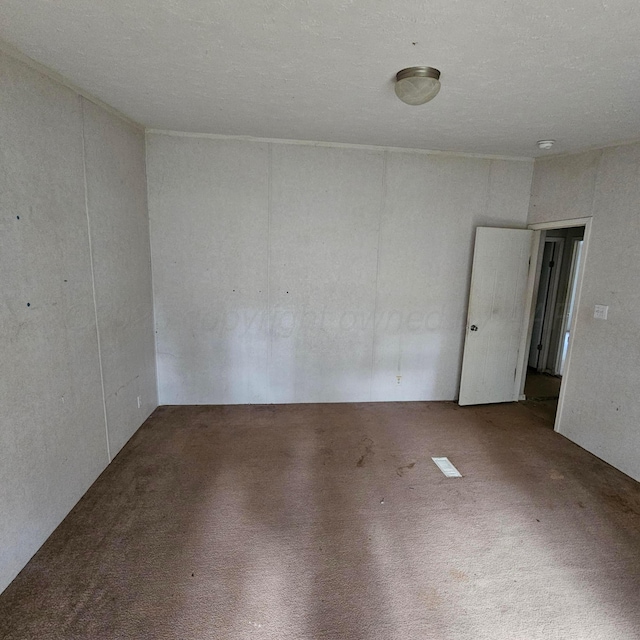 carpeted spare room with a textured ceiling