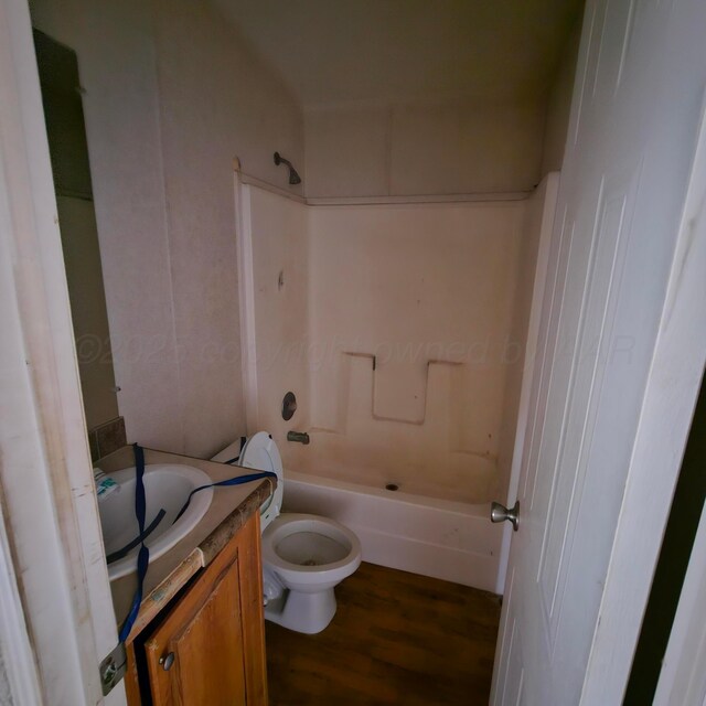 full bathroom with bathing tub / shower combination, hardwood / wood-style floors, vanity, and toilet