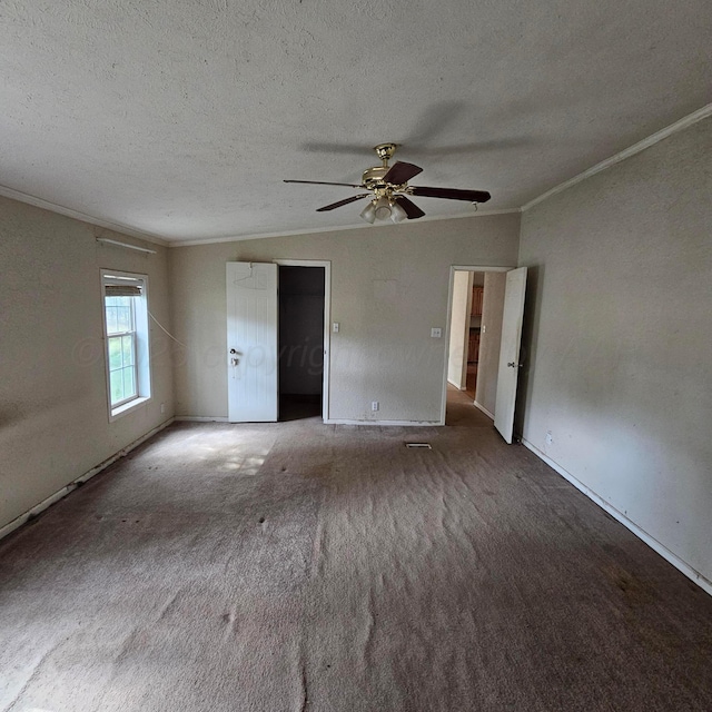 unfurnished room with carpet flooring, a textured ceiling, ceiling fan, and crown molding