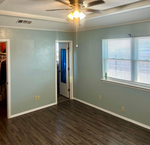 702 Floyd Ave, Dumas, TX 79029 - empty room with dark wood-type flooring, a ceiling fan, baseboards, a textured ceiling, and crown molding