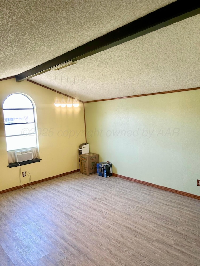 702 Floyd Ave, Dumas, TX 79029 - spare room featuring wood finished floors, a textured ceiling, baseboards, and cooling unit