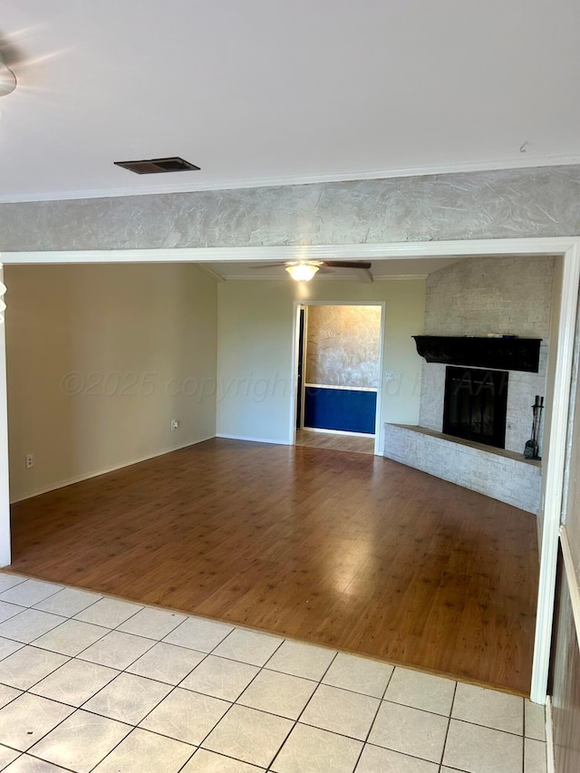 702 Floyd Ave, Dumas, TX 79029 - unfurnished living room featuring light tile patterned flooring, crown molding, and a fireplace