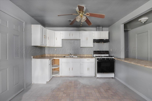 507 N Taylor St, Amarillo, TX 79107 - kitchen with white gas range oven, under cabinet range hood, a ceiling fan, white cabinetry, and light countertops