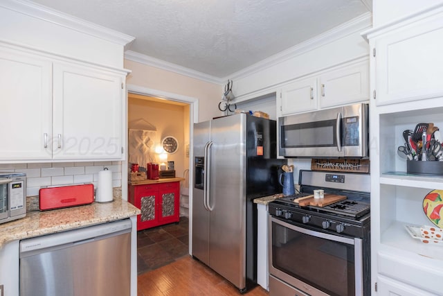 kitchen with appliances with stainless steel finishes, white cabinets, and ornamental molding