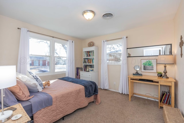 carpeted bedroom featuring visible vents