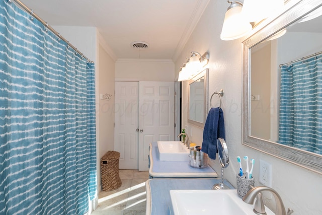 bathroom featuring crown molding, visible vents, a sink, and tile patterned floors