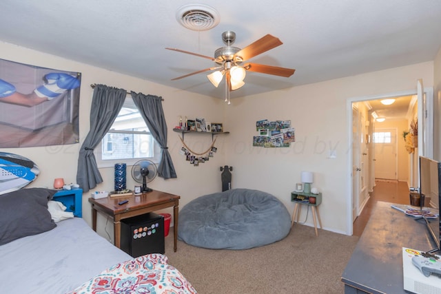 carpeted bedroom with visible vents and a ceiling fan