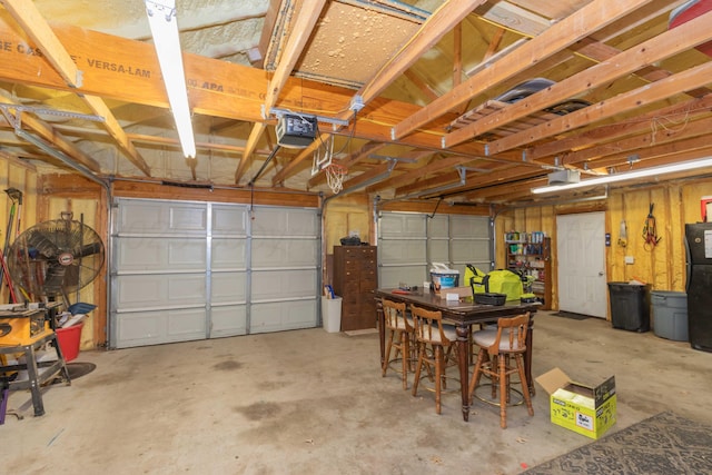 garage featuring a garage door opener and freestanding refrigerator