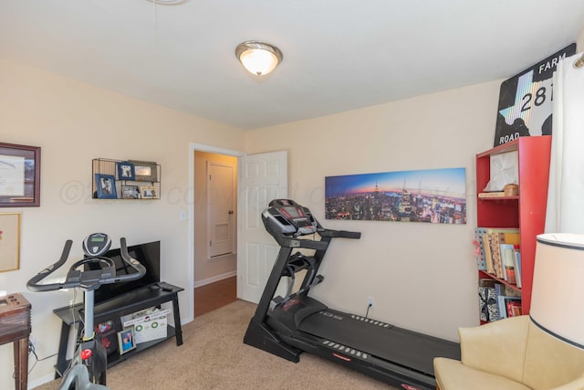 exercise room featuring carpet and baseboards