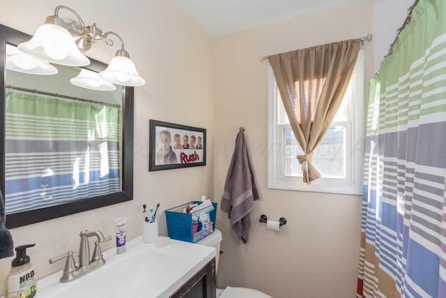 bathroom with toilet, a shower with curtain, and vanity