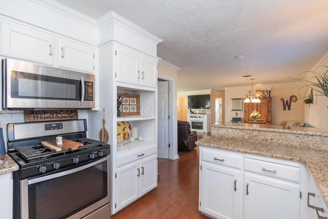 kitchen with dark wood-style floors, appliances with stainless steel finishes, white cabinetry, and crown molding