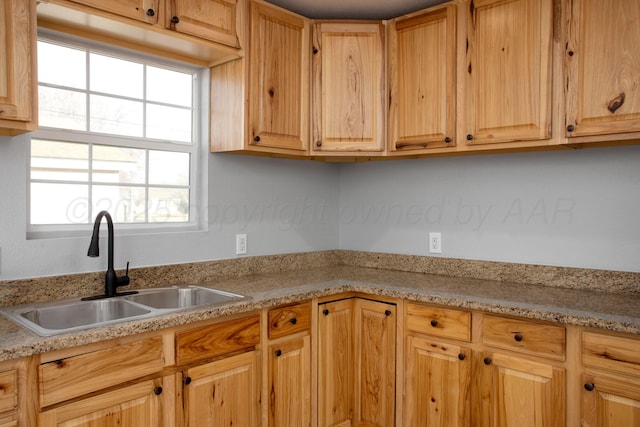 kitchen featuring light countertops, a sink, and light brown cabinetry