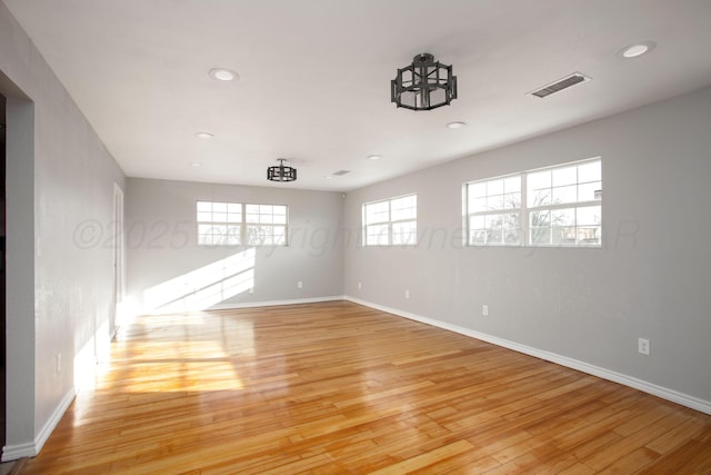 spare room with light wood-style floors, recessed lighting, visible vents, and baseboards