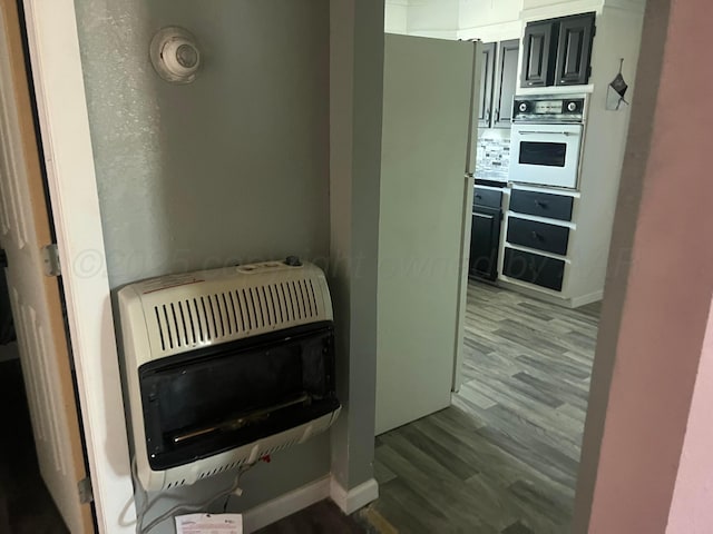 104 Peiffer St, Borger, TX 79007 - interior details featuring heating unit, white appliances, baseboards, and wood finished floors