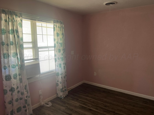 104 Peiffer St, Borger, TX 79007 - empty room featuring a healthy amount of sunlight, dark wood-style flooring, baseboards, and visible vents