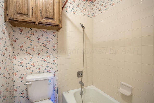 bathroom with bathtub / shower combination, wallpapered walls, and toilet