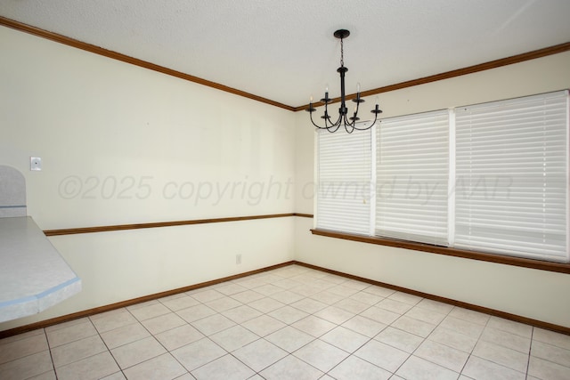 unfurnished room with a chandelier, baseboards, a textured ceiling, and ornamental molding