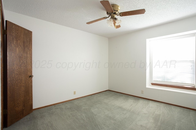 spare room with baseboards, carpet flooring, ceiling fan, and a textured ceiling