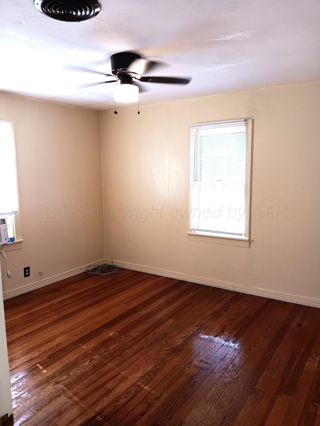 empty room featuring dark wood-style flooring, ceiling fan, and baseboards