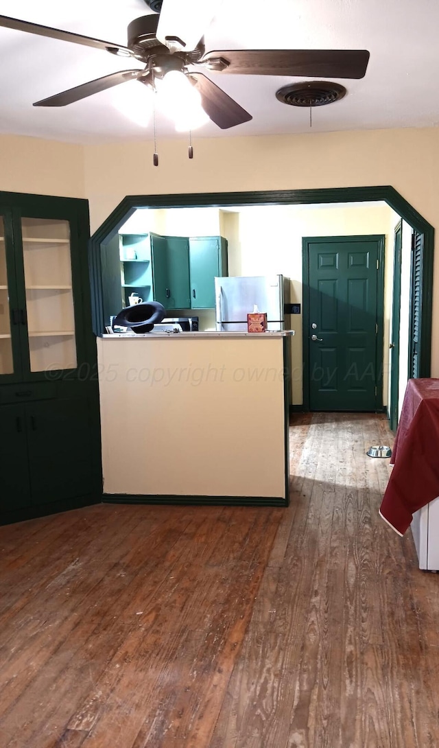 kitchen featuring freestanding refrigerator, ceiling fan, and wood finished floors