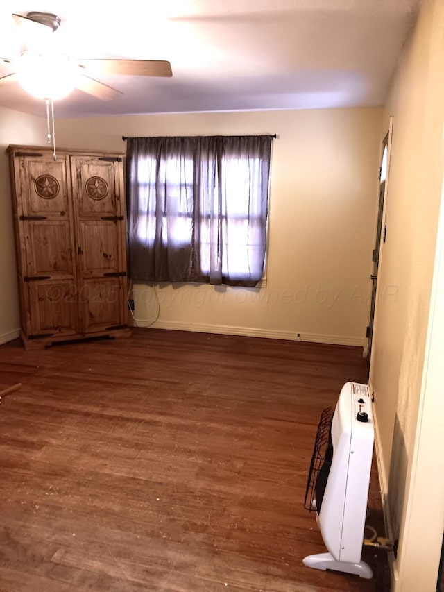 unfurnished room featuring ceiling fan, baseboards, and wood finished floors